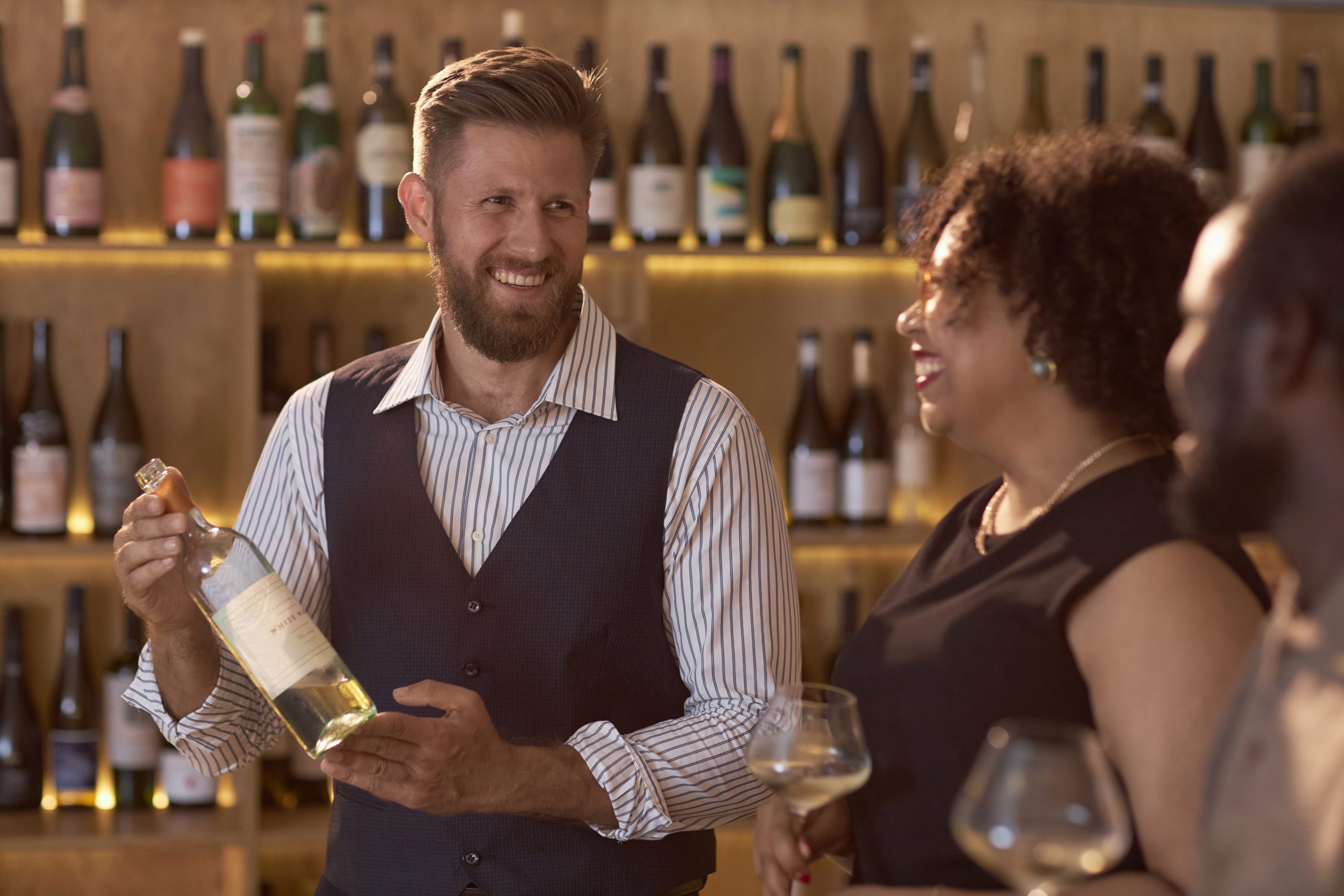 équipe de distributeur de vins servant des clients en boutique