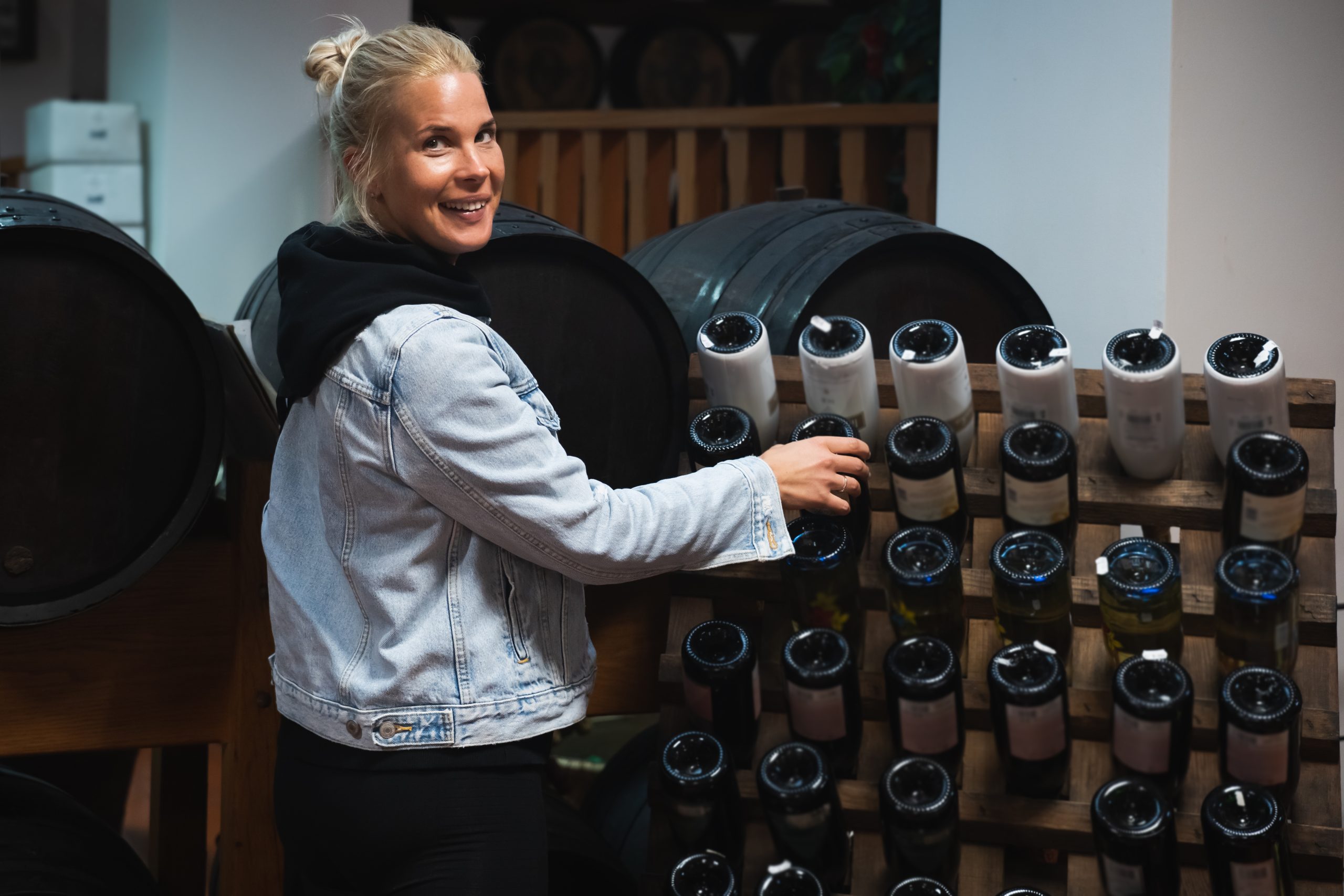 Young happy girl in a wine cellar. distributeur de vins et spiritueux en action