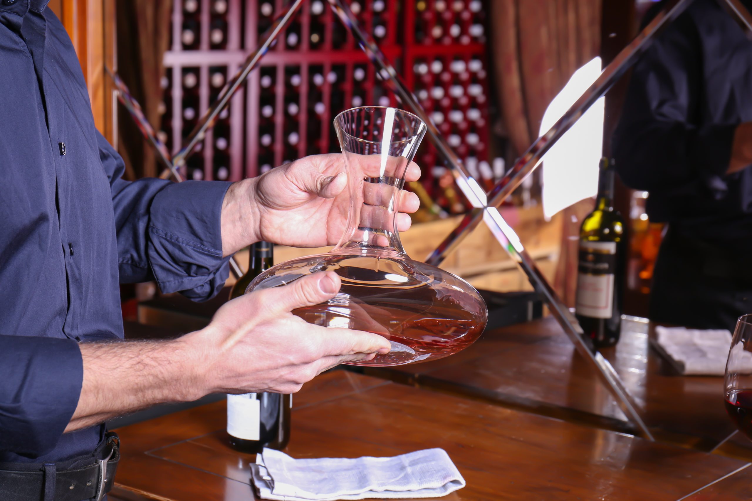 Man holding empty glass decanter for wine dégustation de baijiu Moutai dans une cave à vin à Paris